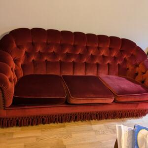 Röd plyschsoffa med klös